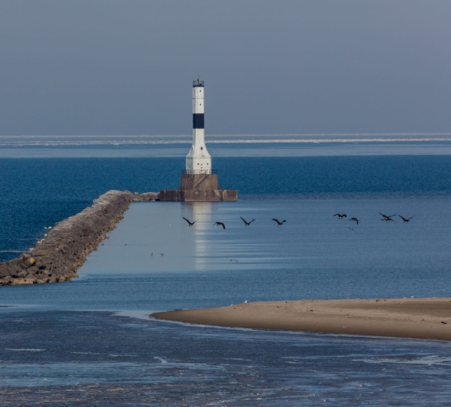 Geese Flying Past Lighthouse by Richard McBride